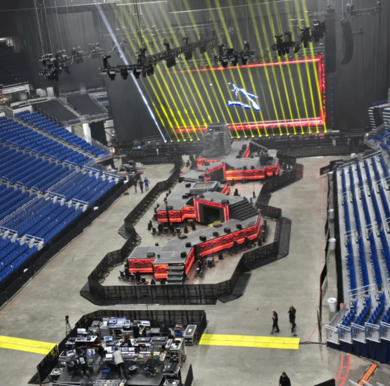 Concert stage with LED walls, lighting beams, and arena seating